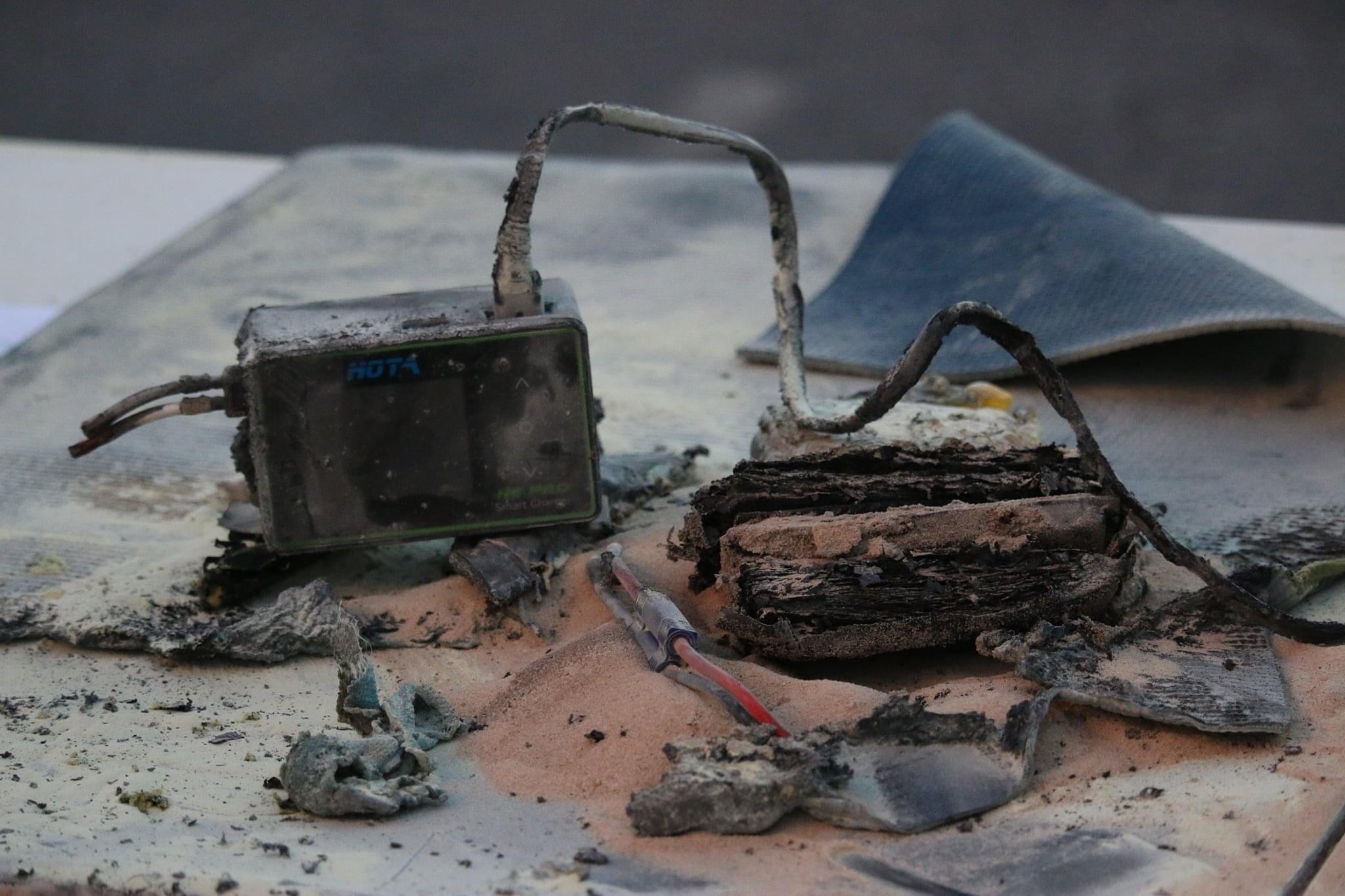A charred lipo battery and charger after a fire